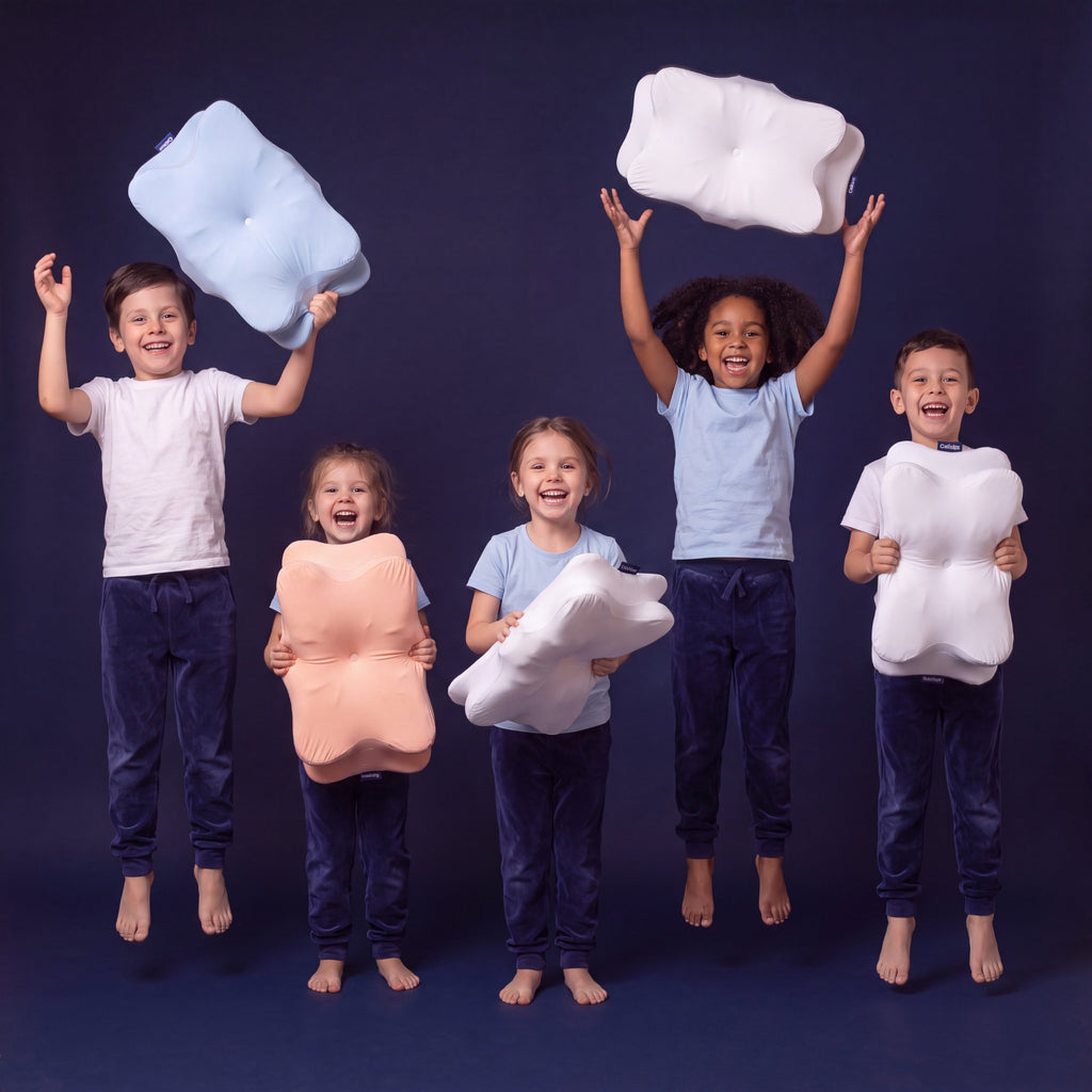 Groupe d'enfants souriants tenant les oreillers ergonomiques Cellsius pour enfant en plusieurs coloris